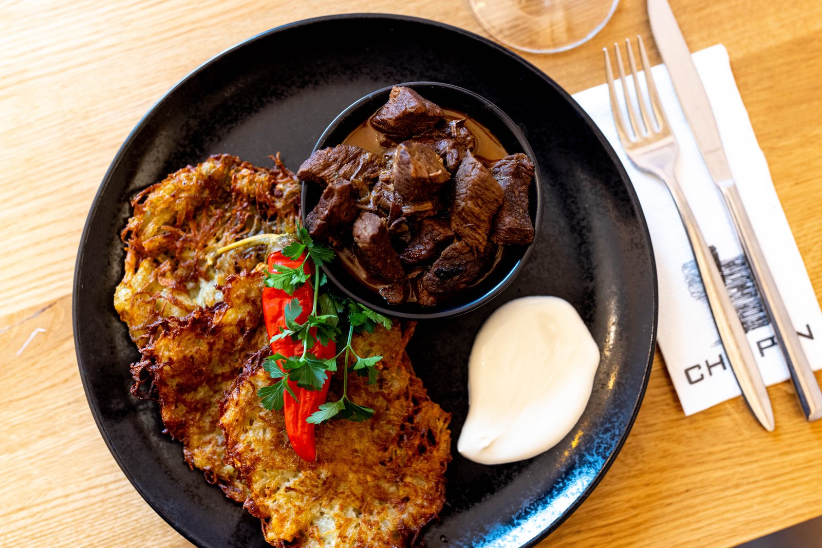 Tradycyjne Polskie Potrawy — potato pancakes and goulash on a CHOPIN napkin